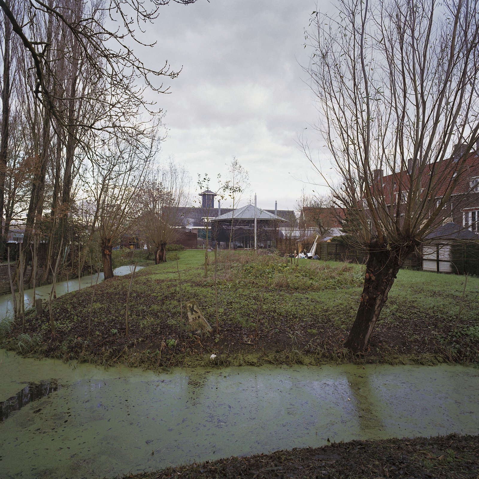 Zeszijdige hooibergkap en dienstwoningen van de voormalige buskruit- en springstoffenfabriek De Oude Molen aan het oostelijke einde van de Ouderkerkerlaan bij de Amstel (december 2005)