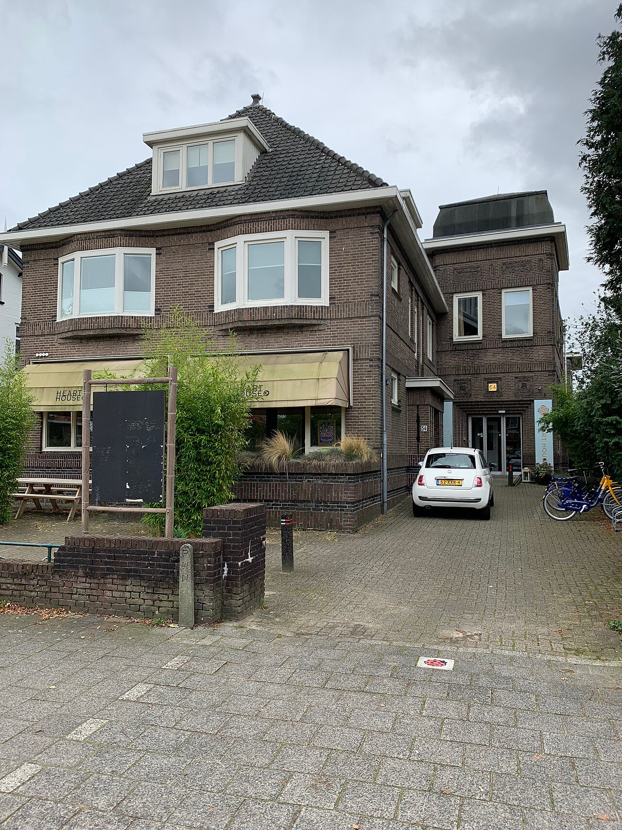 De voormalige Gooische Vakschool voor meisjes (gemeentelijk monument uit 1921, thans Heart House) aan de aangrenzende Huizerweg 54 in Bussum (oktober 2024)