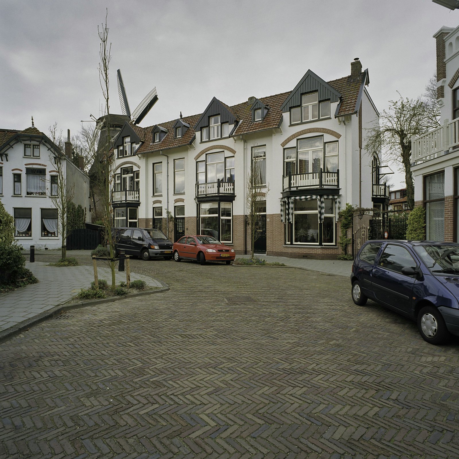 De haakse bocht in de Molenstraat met witgepleisterde herenhuizen en de molen op de achtergrond, 2005.