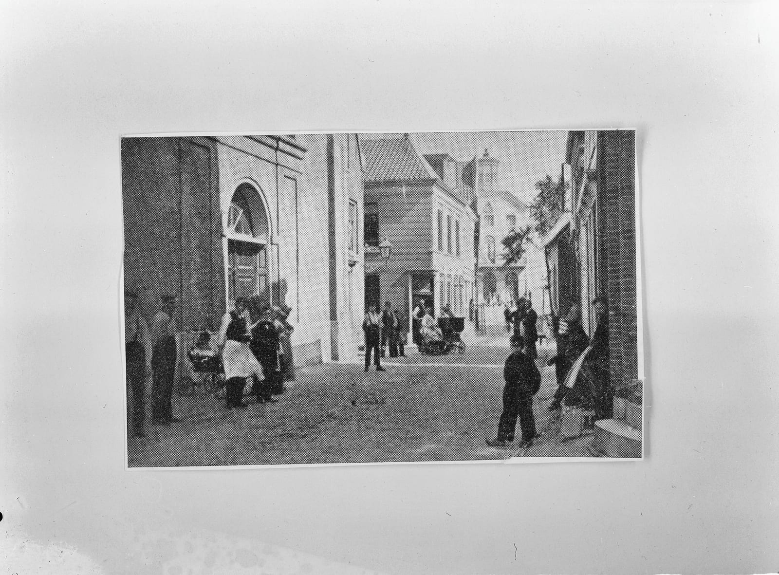 Links de Oostzijderkerk, met ernaast de toegang tot de Kerkstraat en in het midden een tabaks- en grutterswinkel; op de achtergrond het stadhuis. Rond 1900 (datering RCE).